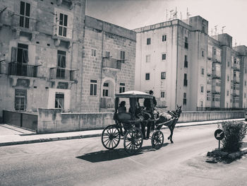 Bicycles parked on road by buildings in city