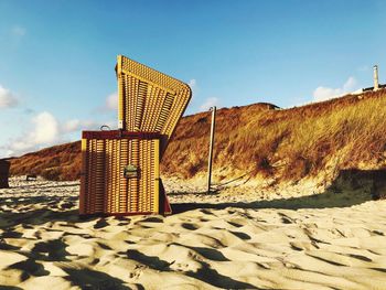 Hooded beach chair against sky