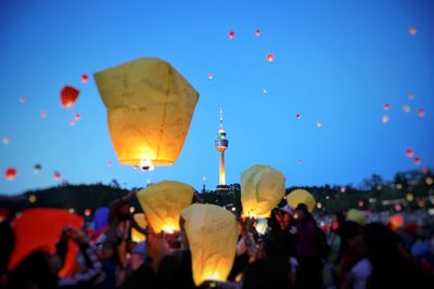 People with balloons against blue sky