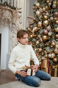 Full length of boy holding christmas tree