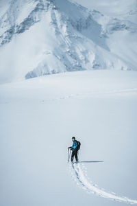 Man on skis enjoying the view at winter wonderland in the austrian alps