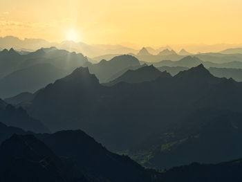 Scenic view of silhouette mountains against sky during sunset