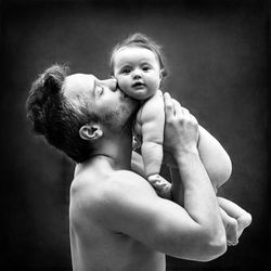 Rear view of father holding daughter standing at home