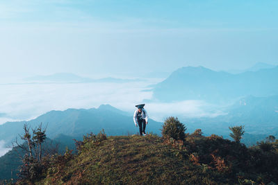 Man standing on mountain against sky