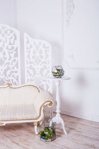 Flower vase on table against wall at home