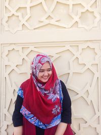 Smiling woman in hijab standing at mosque