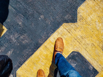 Low section of man walking on road