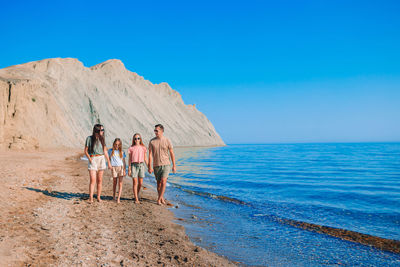 Rear view of people walking on beach