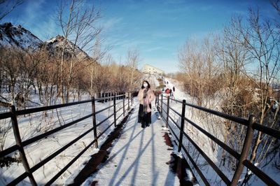 People walking on footbridge during winter