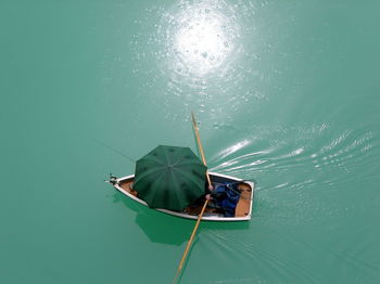 High angle view of person covered with umbrella sailing boat in lake