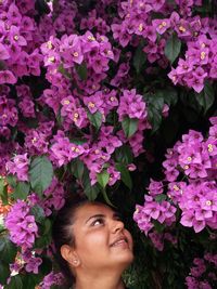 Close-up portrait of smiling young woman with pink flowers