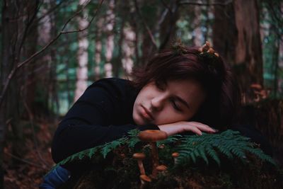 Portrait of young woman looking away in forest