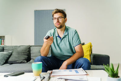 Young man sitting on table at home