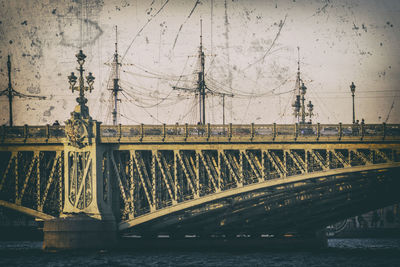 Bridge over river against sky in city