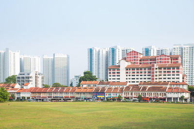 Buildings in city against clear sky