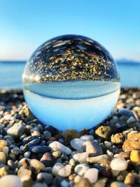 Sea view mirrored in a glass sphere
