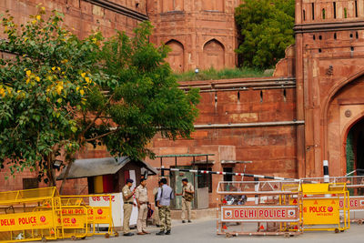 People walking on street amidst buildings in city