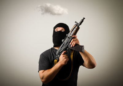 Full length of man playing guitar against white background