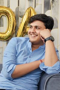 Portrait of young man sitting on sofa at home