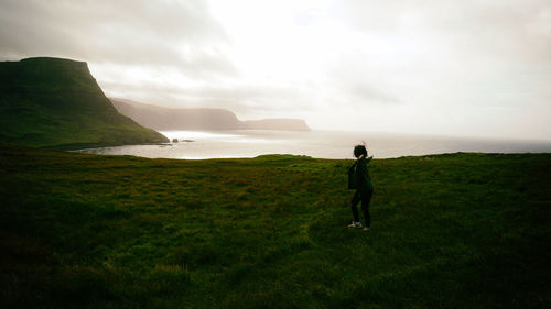 Woman standing on field against sky