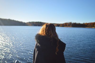Rear view of woman by lake