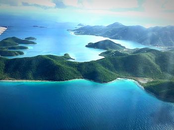 Scenic view of sea and mountains against sky