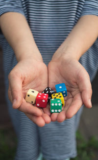 Midsection of girl holding dices