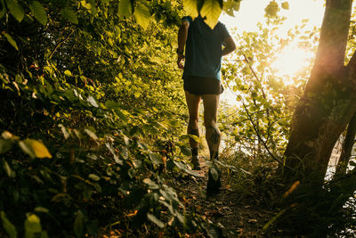 Low section of man running in forest