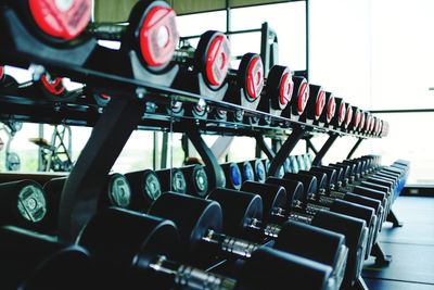 Close-up of dumbbells arranged on rack in gym