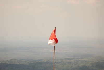 Close-up of red flag against sky at sunset