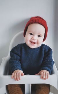 Portrait of cute baby boy sitting on high chair