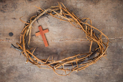 A thorn crown with a wooden cross on a floor with a copy space. 