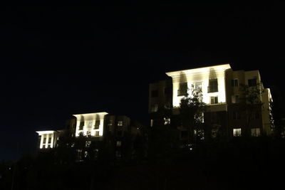 Illuminated city against clear sky at night