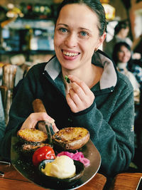 Portrait of smiling young woman having food