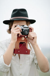 Young man holding camera over white background