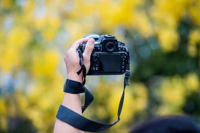 Cropped hand of person photographing with camera