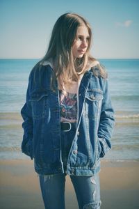 Beautiful young woman standing on sea shore