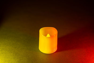 Close-up of illuminated light bulb on table