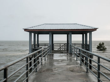 An empty pier by the sea on a rainy day