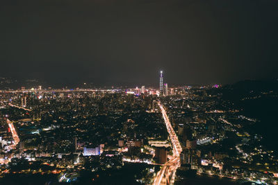 Illuminated cityscape against sky at night