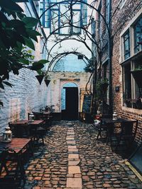 Empty chairs and tables against building