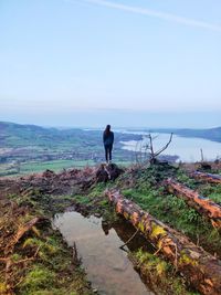 Rear view of man looking at sea against sky