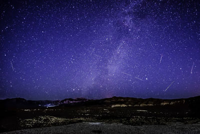 Scenic view of mountains against sky at night