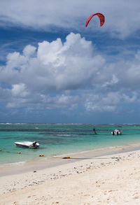 Man kiteboarding in sea against sky