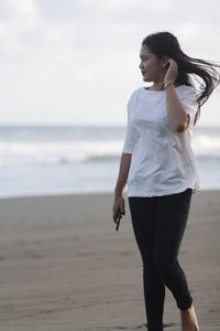 Full length of woman standing at beach