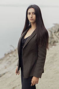 Portrait of beautiful young woman standing on land