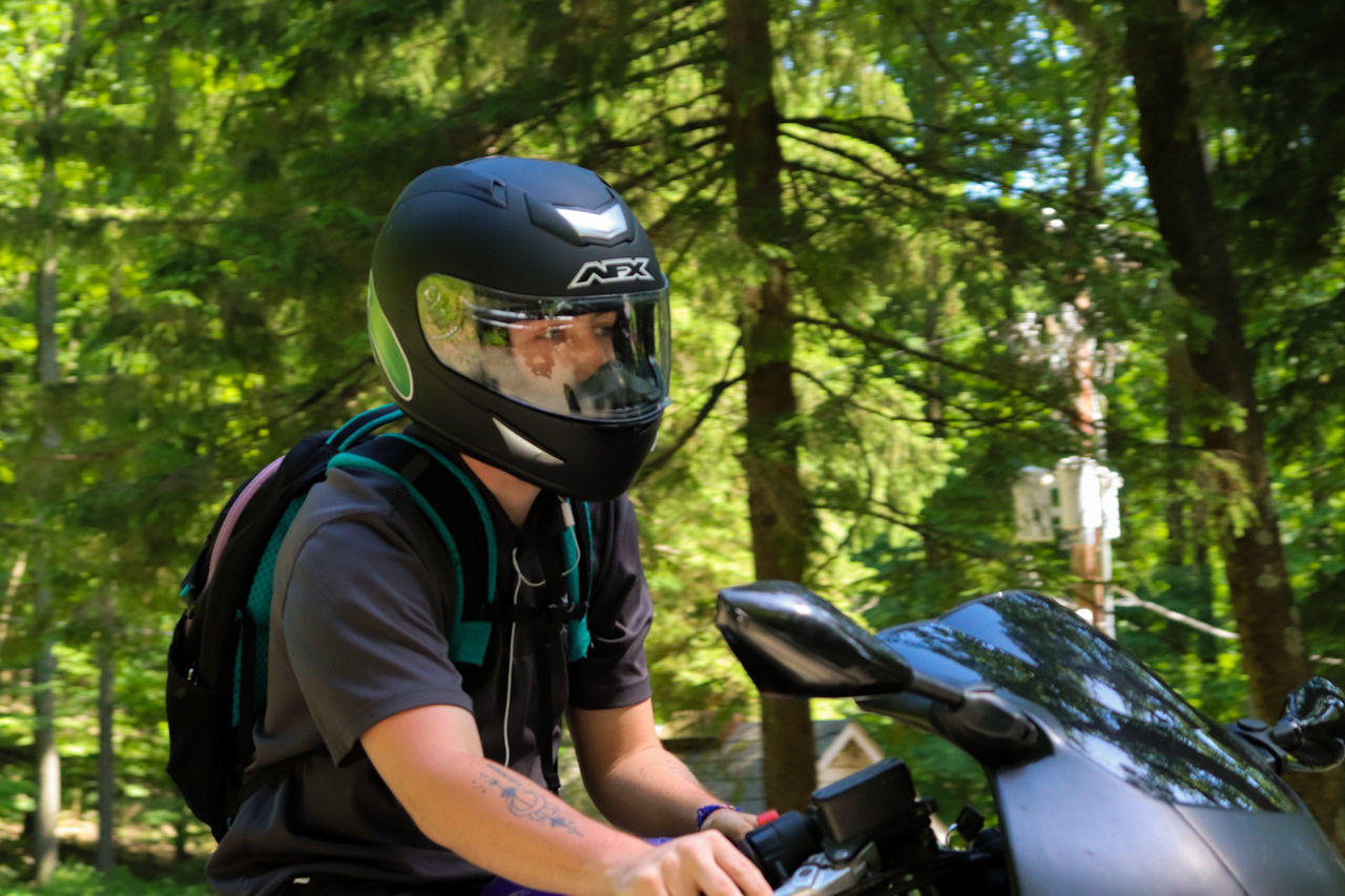 helmet, tree, transportation, one person, headwear, mode of transportation, real people, forest, land vehicle, day, leisure activity, lifestyles, sport, sports helmet, plant, focus on foreground, adventure, bicycle, nature, riding, outdoors, crash helmet