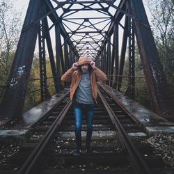 Portrait of young man standing on railroad track