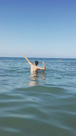 Rear view of man swimming in sea