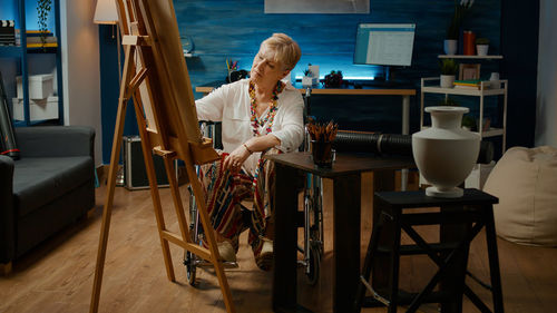 Rear view of woman sitting on table